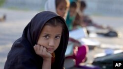 FILE - Pakistani student Farah Muneeb sits with other students at a makeshift school set up by a volunteer in a park in Islamabad, Pakistan on Thursday, Oct 11, 2012. 
