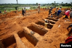 FILE - Workers dig graves for mudslide victims at the Paloko cemetery in Waterloo, Sierra Leone, Aug. 17, 2017.