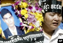 រូបឯកសារ៖ សមាជិក​សហជីព​មួយ​រូប​យំ​នៅ​ក្បែរ​កម្រង​ផ្កាដែល​មាន​រូបថត​លោក ជា វិជ្ជា ប្រធាន​សហជីព​សេរី​កម្មករ ក្នុង​អំឡុង​ពេល​ពិធី​បុណ្យ​សព​របស់​លោក​កាល​ពី​ថ្ងៃ​អាទិត្យ​ទី​២៥ ខែ​មករា ឆ្នាំ​២០០៤ នៅ​រាជធានី​ភ្នំពេញ។ លោក ជា​ វិជ្ជា ត្រូវ​បានរូបឯកសារ៖ ​សម្លាប់កាល​ពី​ថ្ងៃ​ព្រហស្បតិ៍​ខណៈ​ដែល​លោក​កំពុង​អាន​នៅ​តូប​កាសែត​មួយ​នៅ​ក្រុង​ភ្នំពេញ។ (AP Photo/Andy Eames)