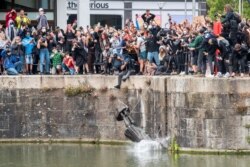 FILE - The statue of 17th century slave trader Edward Colston falls into the water after protesters pulled it down during a protest against racial inequality, in Bristol, Britain, June 7, 2020. (Keir Gravil via Reuters)