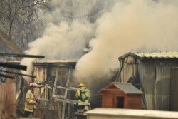 Firefighters tend to burning property caused by bushfires in Bargo, southwest of Sydney, Australia, Dec. 21, 2019.