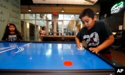 Anthony Martinez, 9, right, and Samantha Huizar, 6, left, attend a special day camp at the Salvation Army Kroc Center because schools were closed due to the Arizona teacher strike in Phoenix, April 26, 2018.