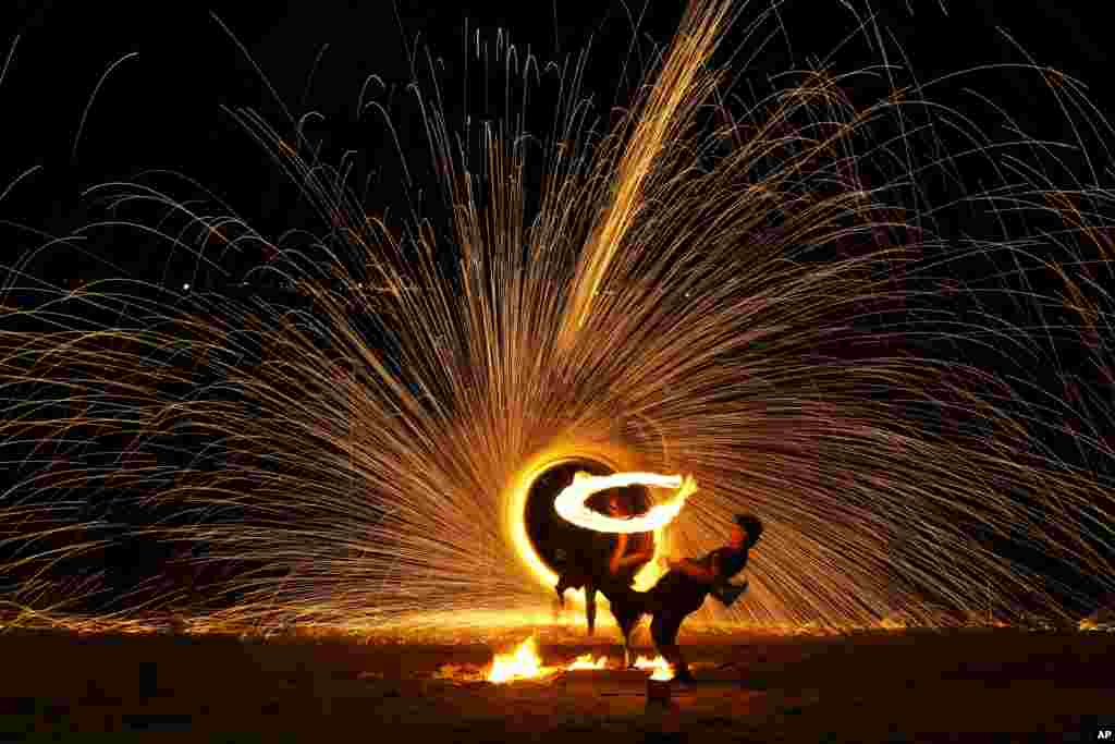 Malay artists perform a fire sparkling performance on a beach side during the Christmas festive season and school holidays on Pangkor Island, Malaysia.