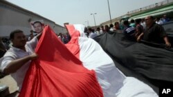 Supporters of Egypt's deposed president Hosni Mubarak wave a large national flag in front of Torah Prison in Cairo, Aug. 22, 2013. 