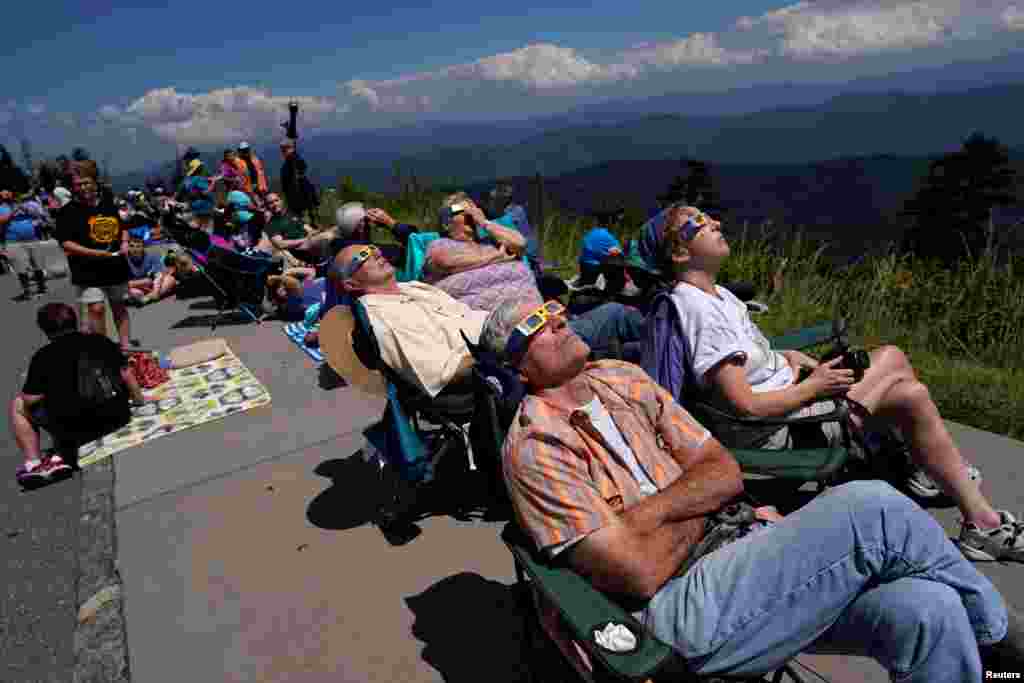 People watch as the solar eclipse approaches totality from Clingmans Dome, which at 6,643 feet (2,025m) is the highest point in the Great Smoky Mountains National Park, Tennessee, Aug. 21, 2017. 