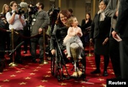 Senator Tammy Duckworth (D-IL) carries her daughter Abigail during a mock swearing in with U.S. Vice President Joe Biden during the opening day of the 115th Congress on Capitol Hill in Washington, Jan. 3, 2017.