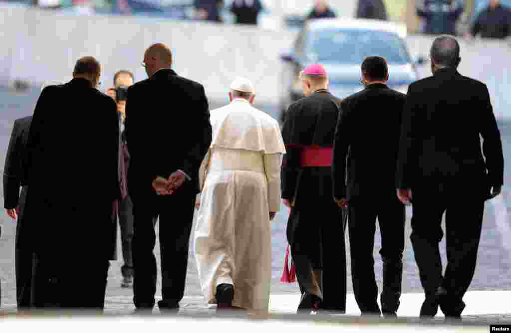 Pope Francis leaves the Paul VI hall with security at the Vatican, March 16, 2013. 
