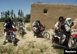 FILE - Taliban fighters ride on motorbikes in an undisclosed location in Afghanistan, July 14, 2009.