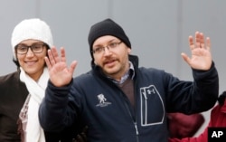 U.S. journalist Jason Rezaian gestures next to his wife Yeganeh Salehi as he poses for media people in front of Landstuhl Regional Medical Center in Landstuhl, Germany, Wednesday, Jan. 20, 2016. Rezaian was released from an Iranian prison last Saturday.