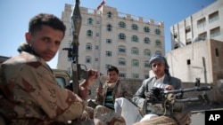This Apr.19, 2017 file photo, Shiite fighters, known as Houthis, pose for a photo as they secure a road, as people take part in a march from Sanaa to the port city of Hodeidah, Yemen.