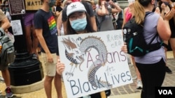 一名手持中文牌子的抗议者参加在华盛顿2020年6月6日举行的反警暴游行。（美国之音记者文灏拍摄）