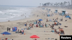People relax at the ocean in Huntington Beach, California, July 23, 2020. 