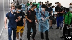 Three members of the Olympic refugee team, from left, Ahmad Alikaj, Abdullah Sediqi and coach Alireza Nassrazadany arrive at Narita international airport in Narita, Chiba prefecture, on July 14, 2021.