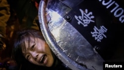 Policija hapsi demonstrantkinju protiv zakona o izručenju, na protestima u Hong Kongu 2. septembra 2020. Rojters je osvojio Pulicerovu nagradu za seriju fotografija sa tih protesta.