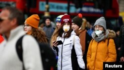 People are pictured wearing protective face masks in London, March 2, 2020.