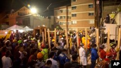 Volunteers bring pieces of wood to help prop up sections of the collapsed Enrique Rebsamen school, as rescue workers search for children trapped inside, in Mexico City, Sept. 19, 2017. Rescuers brought in wooden beams to shore up the fallen concrete slabs so they wouldn't collapse further and crush whatever airspaces remained.