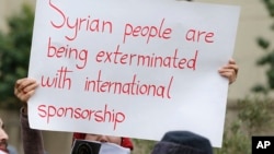  A woman holds a placard during a protest in solidarity with residents of the Syrian capital's eastern suburb of Ghouta, in front the Russian embassy in Beirut, Lebanon, Sunday, Feb. 25, 2018.