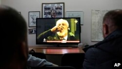 Warga Kota Mostar, sekitar 140 kilometer dari Sarajevo, melihat siaran langsung dari Mahkamah Pidana Internasional di Den Haag, persidangan Slobodan Praljak, 29 November 2017. Dalam siaran itu terlihat Slobodan menenggak dari sebuah wadah. 
