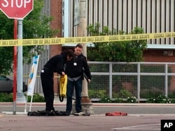 Fresno police stand next to a pile of clothes in front of a corner market in the neighborhood where shootings occurred in Fresno, Calif., April 18, 2017. A man shot and killed three people on the streets of downtown Fresno shouting "God is great" in Arabic during at least one of the slayings and later telling police that he hates white people, authorities said.