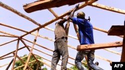 Les charpentiers sur une maison en pisé, dans le village de Toubakouta, à 9 kilomètres au sud de Ziguinchor, dans la région sud de la Casamance, le 12 mai 2017.