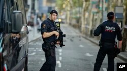 Polisi bersenjata melakukan patroli di kawasan La Rambla, Barcelona hari Jumat (18/8). 