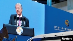 កញ្ចក់អេក្រង់បង្ហាញនាយករដ្ឋមន្រ្តីម៉ាឡេស៊ី Mahathir Mohamad ថ្លែងសុន្ទរកថានៅក្នុងពិធីបើកវេទិកាក្រវាត់ផ្លូវពាណិជ្ជកម្មលើកទី២ នៅជាប់នឹងរូបចម្លងនៃផ្លូវរថភ្លើងល្បឿនលឿនរបស់ចិនក្នុងទីក្រុងប៉េកាំងប្រទេសចិនថ្ងៃទី ២៦ ខែមេសាឆ្នាំ ២០១៩ ។ (REUTERS/Jason Lee)