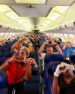This Friday, March 27, 2020, photo provided by Southwest Airlines employee Dayartra Etheridge shows health care workers, other passengers and flight crew aboard a Southwest flight from Atlanta to New York's LaGuardia Airport.