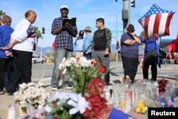 Mourners gather around a makeshift memorial in honor of victims following Wednesday's attack in San Bernardino, California December 5, 2015.