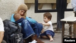 FILE - A Syrian refugee family waits in the Aegean port city of Izmir, western Turkey, Aug, 10, 2015.