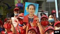 Myanmar migrants hold up portraits of detained leader Aung San Suu Kyi as they rally outside Myanmar's embassy in Bangkok, Thailand, Feb. 1, 2021.