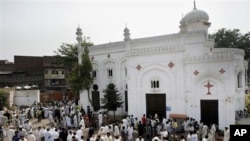 Orang-orang berkumpul di depan sebuah gereja di Peshawar, Pakistan, pasca serangan bom bunuh diri (22/9). 