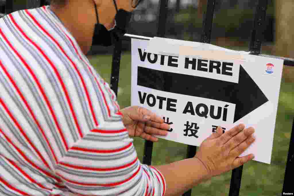 An election worker posts signage outside a polling station at the James Weldon Johnson Community Center on Election Day in Harlem in the Manhattan borough of New York City, New York, Nov. 3, 2020.