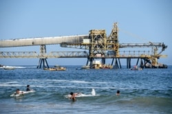 People cool off in the beach near the mining pipeline "Puerto Coloso" of the "Escondida" cooper mine in Antofagasta, Chile, Feb. 16, 2017.