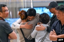Penumpang Singapore Airlines penerbangan SQ321 dari London menuju Singapura yang melakukan pendaratan darurat di Bangkok, menyapa anggota keluarga setibanya di Bandara Changi di Singapura, 22 Mei 2024.
