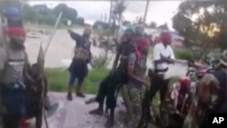 FILE - Image taken from militant video released by the Islamic State group on March 29, 2021, purporting to show fighters near the strategic north eastern Mozambique town of Palma.