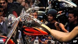 নয়াদিল্লিতে অটো এক্সপো চলাকালীন ভারতীয়রা হার্লে ডেভিডসন মোটরসাইকেলের ছবি তুলছে। ৭ জানুয়ারি, ২০১২। ফাইল ছবি।