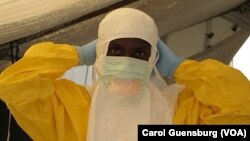 FILE - A health worker adjusts protective gear at a Doctors Without Borders' Ebola treatment unit in Conakry, Guinea. (VOA / Carol Guensburg) 