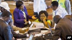 Official representatives of the various political parties and electoral workers discuss while reviewing newly received results, at the National Tallying Center in Nairobi, Kenya, March 6, 2013.