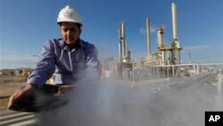 FILE - In this photo from February 2011, an employee works at an oil refinery in eastern Libya. 