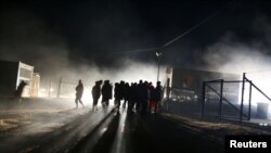 People stand at camp "Lipa" after it was closed, in Bihac, Bosnia and Herzegovina December 30, 2020. REUTERS/Dado Ruvic