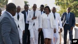 Accompanied by First Lady Martine Moïse, center right, and and acting prime minister Jean Michel Lapin, center left, President Jovenel Moise, center, arrives to lay flowers to mark the anniversary of the death of Haitian revolution leader.