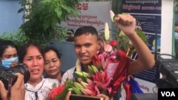 យុវជន កាក់ សុវណ្ណច្ឆ័យ អាយុ​១៦ឆ្នាំ លើក​ដៃ​ឆ្វេង ក្រោយ​ត្រូវបាន​ដោះលែង​ពី​ពន្ធនាគារ នៅ​ថ្ងៃទី១០ ខែវិច្ឆិកា ឆ្នាំ២០២១។ (មាស មល្លិកា/វីអូអេ)