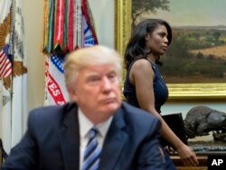 FILE - In this March 12, 2017 file photo, White House Director of communications for the Office of Public Liaison Omarosa Manigault, right, walks past President Donald Trump during a meeting on healthcare in the White House.