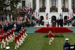 Brigitte Macron, first lady Melania Trump, French President Emmanuel Macron, and President Donald Trump look on during a State Arrival Ceremony on the South Lawn of the White House, April 24, 2018, in Washington.