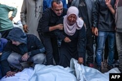 Warga Palestina menangis di depan jenazah orang-orang yang tewas dalam serangan Israel, di Rumah Sakit Syuhada al-Aqsa di Deir Al-Balah di Jalur Gaza bagian tengah, 17 November 2024. (Foto: AFP)