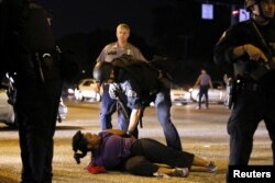 A woman protesting the shooting death of Alton Sterling is detained by law enforcement near the headquarters of the Baton Rouge Police Department in Baton Rouge, Louisiana, July 9, 2016.