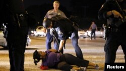 A woman protesting the shooting death of Alton Sterling is detained by law enforcement near the headquarters of the Baton Rouge Police Department in Baton Rouge, Louisiana, July 9, 2016. 