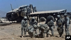 Soldiers assist a NATO soldier wounded by an IED explosion in Kandahar province in southern Afghanistan, 12 Oct 2010