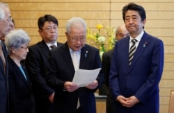 아베 신조 일본 총리가 2018년 3월 도쿄 총리 관저에서 납북자 가족들과 만나고 있다. 아베 총리는 이 자리에서 다음달 미국을 방문해 트럼프 대통령과 정상회담을 할 계획이며, 납북자 문제를 논의할 것이라고 밝혔다.