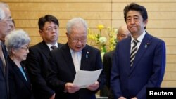 지난 2018년 이즈카 시게오 전 회장이 아베 신조 당시 일본 총리에게 가족들의 입장을 전하고 있다. (자료사진)